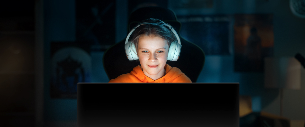 A girl playing a game in a dark room. Highlighting how OLED displays offer the best image quality without causing glare and allows comfort for the eye in any environment.